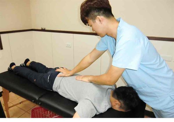 物理治療師孫偉傑(右)以徒手治療的微調,減少病人脊椎神經壓迫引起的痠麻痛無力。(圖片提供/活力得中山脊椎外科醫院)